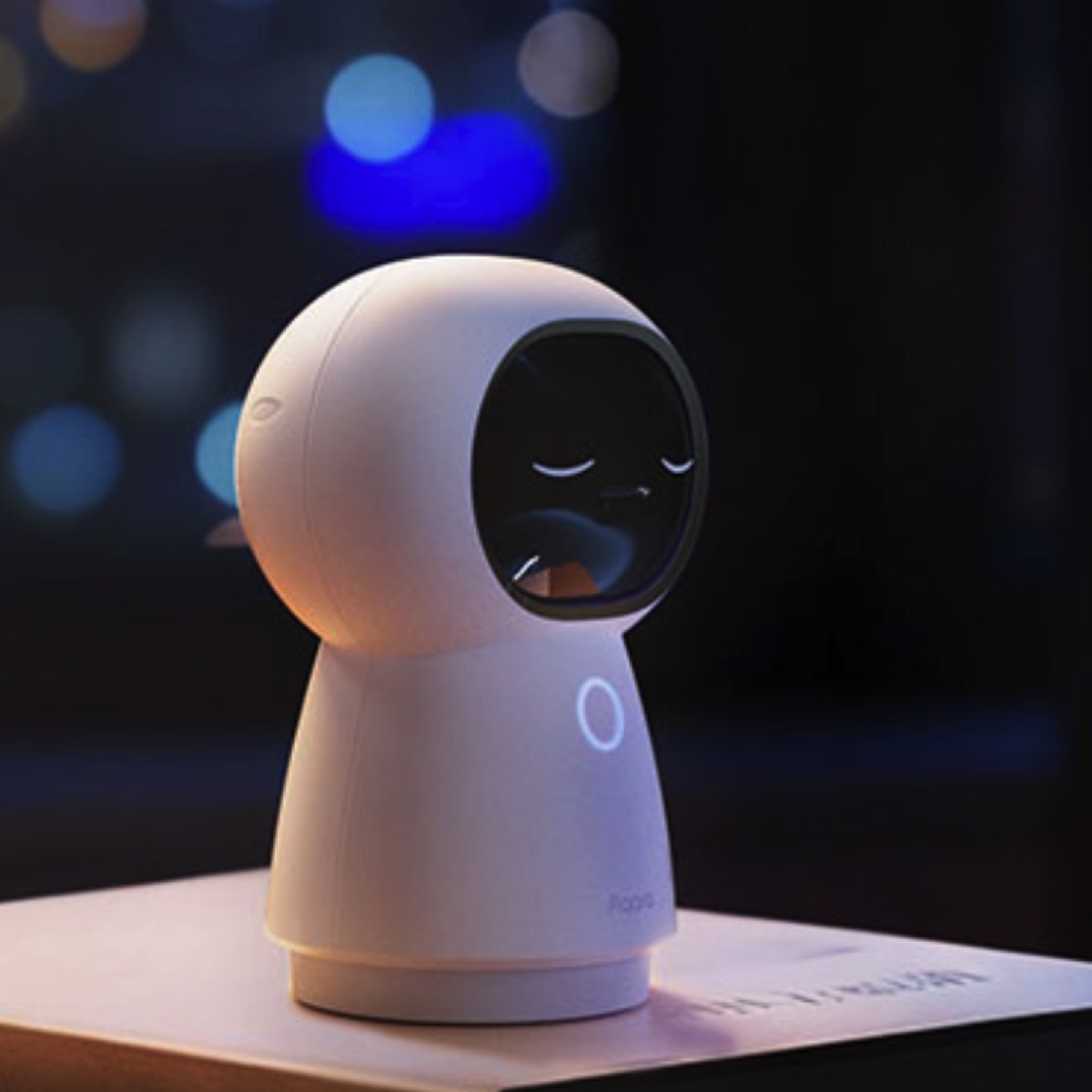 Aqara Camera Hub G350 auf einem Tisch vor unscharfen Lichtern