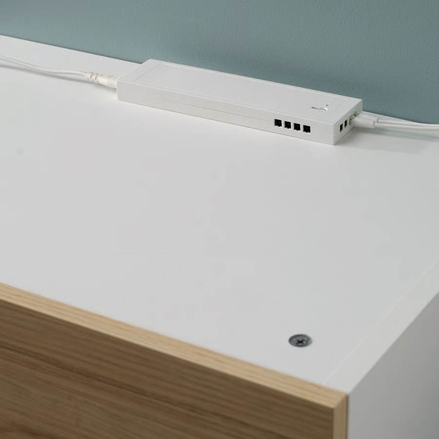 White IKEA LED driver with several connectors on top of a cabinet