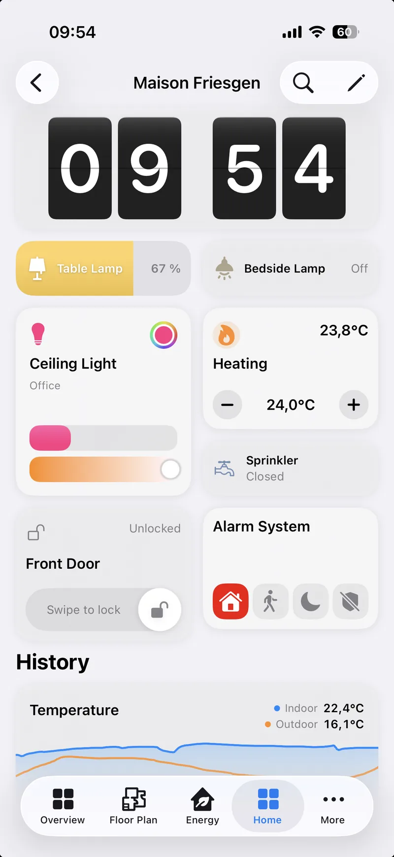 A dashboard on an iPhone: a flip clock, two lamp tiles, a ceiling light with a colour picker and two sliders, heating with current and target, a sprinkler, the front door lock with a slide to lock, the alarm system with its four modes, and below them a History section with an indoor and outdoor temperature chart